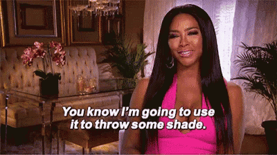 a woman in a pink dress is smiling and saying you know i 'm going to use it to throw some shade