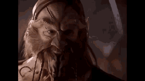 a close up of a man wearing a mask with a beard .