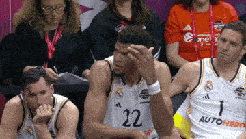 a basketball player with the number 22 on his jersey sits in the stands