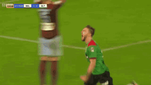 two soccer players are celebrating a goal on a field
