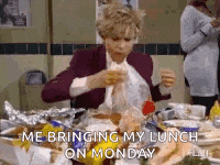 a woman is sitting at a table with a bunch of food and eating .