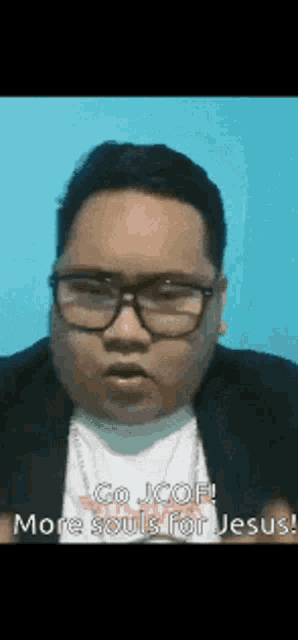 a man wearing glasses and a black jacket is talking about jesus .
