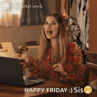 a woman is sitting at a desk with a laptop and says happy friday