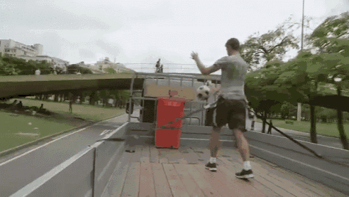 a man is holding a soccer ball on the back of a truck ..