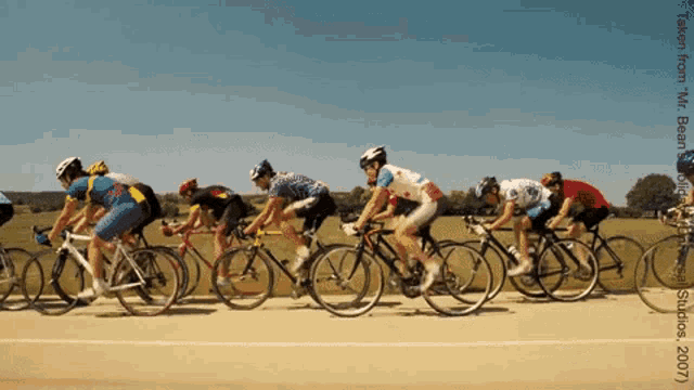 a group of people are riding bicycles on a dirt road and the photo was taken by mr. bean in 2007