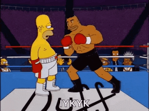 homer simpson and mike tyson are boxing in a ring .