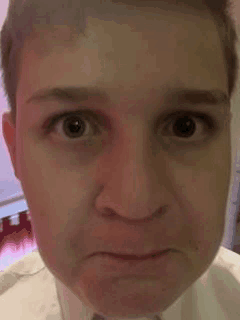a close up of a man 's face with a sad look on his face .