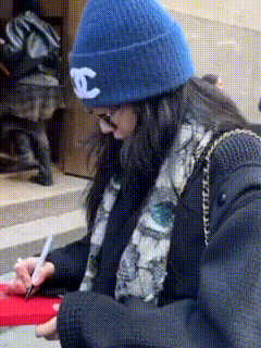 a woman wearing a blue hat with a white chanel logo on it