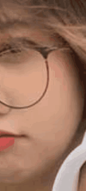 a close up of a woman 's face wearing glasses and headphones .