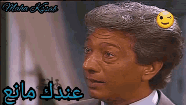 a close up of a man 's face with arabic writing and a smiley face on his forehead