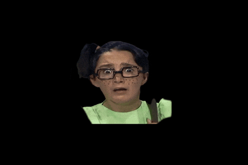 a girl with glasses and freckles on her face makes a surprised face