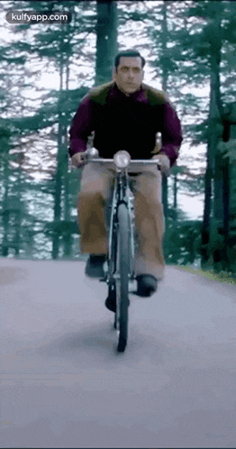 a man is riding a bike down a road .