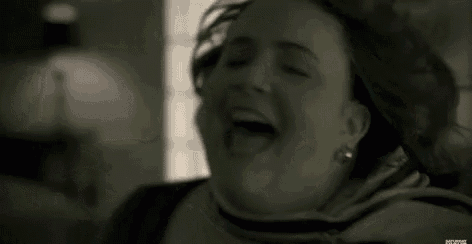 a woman is laughing with her mouth open and her tongue sticking out .