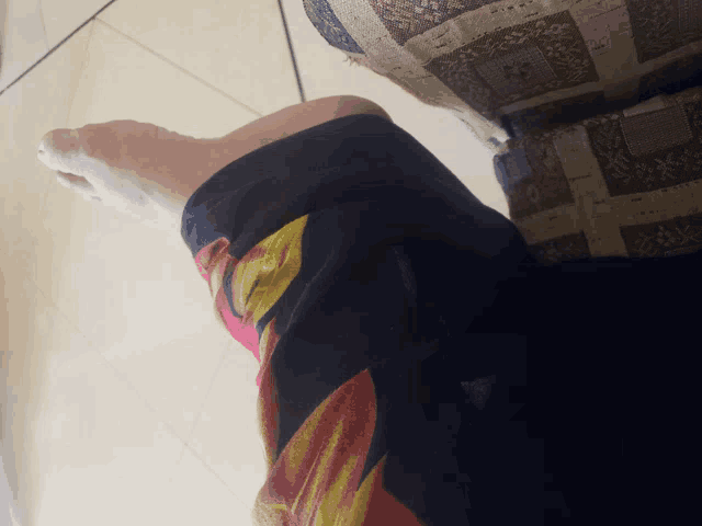 a close up of a person 's foot wearing a black and red shirt