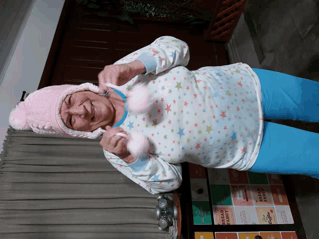 an elderly woman wearing a pink hat and a white shirt with stars