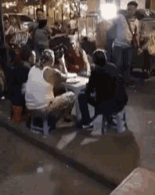a group of people are sitting around a table .