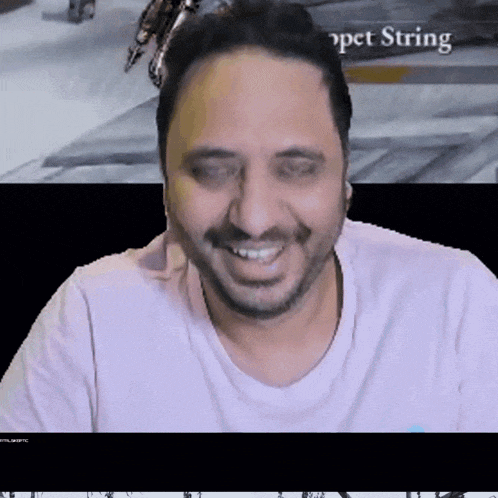 a man in a pink shirt is smiling in front of a screen that says " pet string "