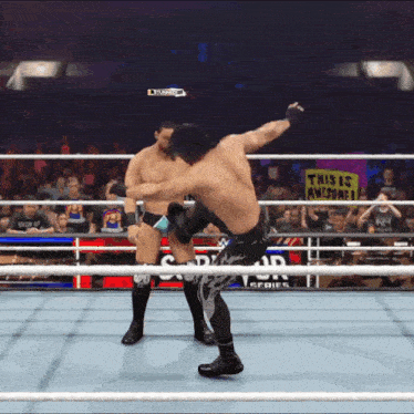 two wrestlers are fighting in a ring with a sign that says this is awesome