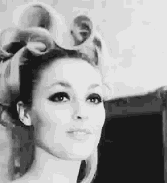 a black and white photo of a woman with her hair in curlers .
