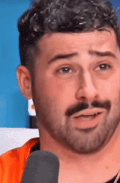 a close up of a man 's face with a microphone in front of him