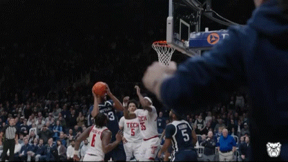 a basketball game is being played in front of a crowd with a pnc ad on the hoop .