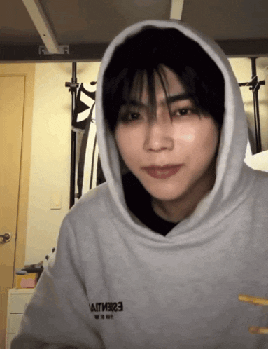 a person wearing a grey hoodie with the letters e2e on the front