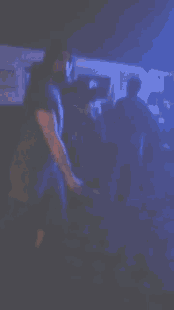 a group of people are dancing in a dark room