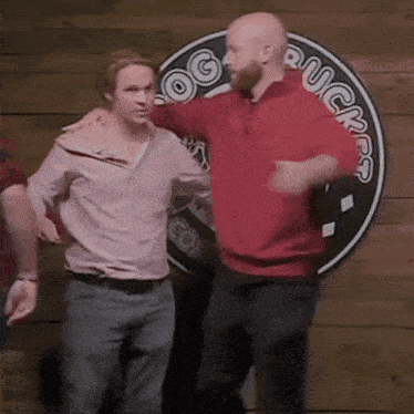 two men are dancing in front of a sign that says rough