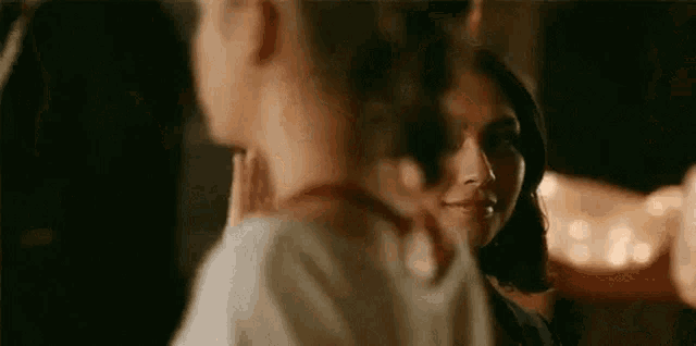 a man and a woman are standing next to each other in a dark room .