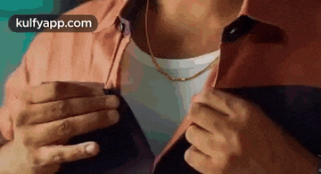 a close up of a man 's neck and chest while holding his jacket open .
