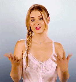 a woman in a braided ponytail is making a funny face with her hands outstretched