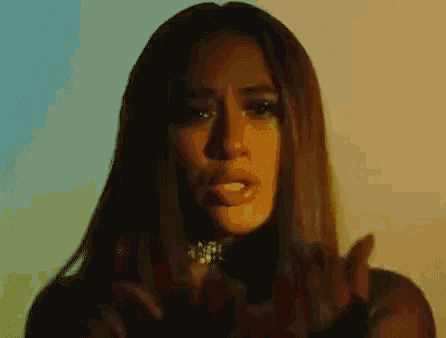 a woman with long hair and a choker on her neck is making a funny face .