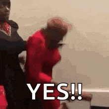 a man in a red shirt is holding a woman in a red dress and says yes .