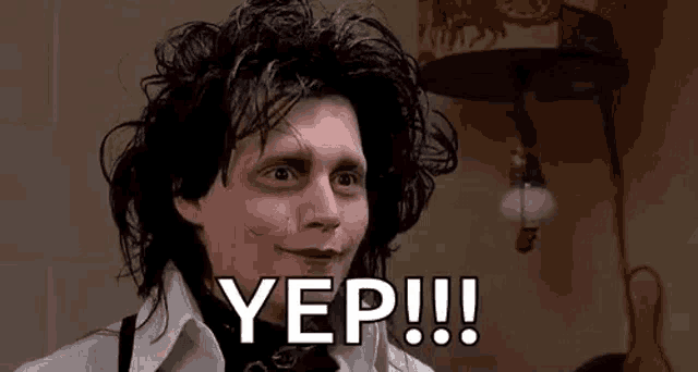 a man with black hair and a white shirt is standing in front of a lamp and saying yep .