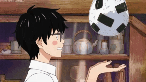 a person holding a soccer ball in their hand in front of a shelf
