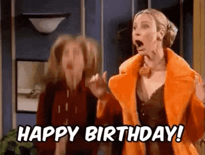 a woman in an orange coat is standing next to another woman and says `` happy birthday '' .