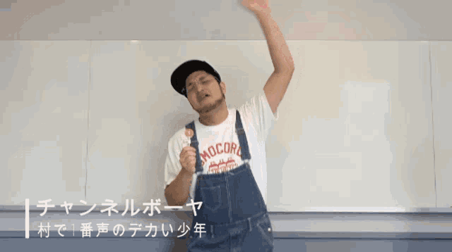 a man wearing overalls and a shirt that says mocord