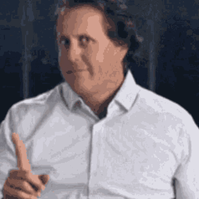 a man in a white shirt is pointing at something