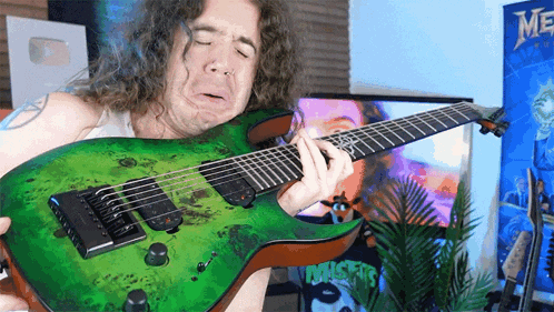 a man with curly hair is playing a green guitar in front of a sign that says miser
