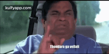 a man is sitting in the back seat of a car making a funny face and giving the middle finger .