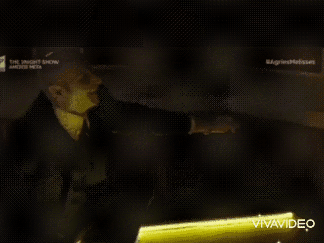 a man in a suit and tie is on a tv screen that says the night show on it
