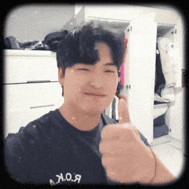 a man giving a thumbs up with a shirt that says b.o.k. on it