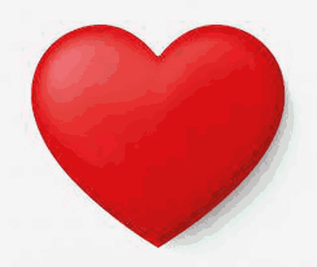 a red heart is sitting on a white background .