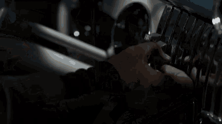 a man and a woman are driving a convertible car in a garage at night .