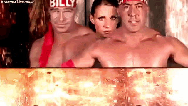 a man and a woman are standing next to each other in a room with fire coming out of it .
