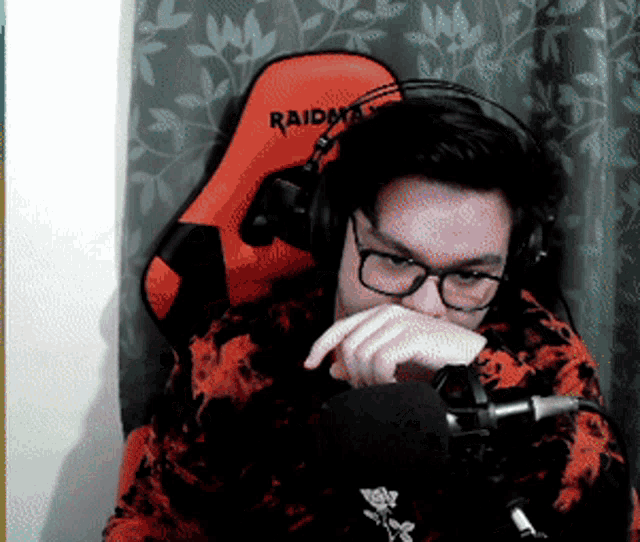 a man wearing headphones and a raidmax chair