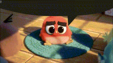 a red angry bird with big eyes is sitting on a rug
