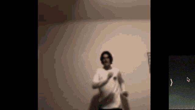 a blurry picture of a man dancing in a room with headphones on .