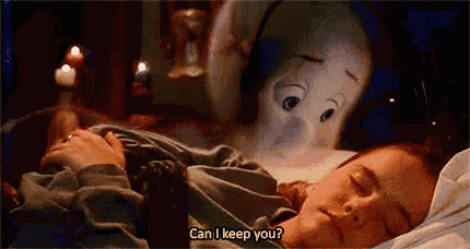 a woman is sleeping in a bed with a stuffed animal behind her .