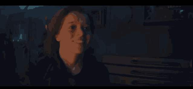 a close up of a woman 's face in a dark room .